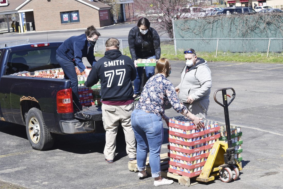Workers of The Salvation Army in Jamestown are pictured Monday morning unloading food, including chicken noodle soup, tomato sauce and canned fruit. The organization's food pantry served 300 more households in March than on average, most likely due to layoffs associated with the coronavirus pandemic. P-J photos by Eric Tichy