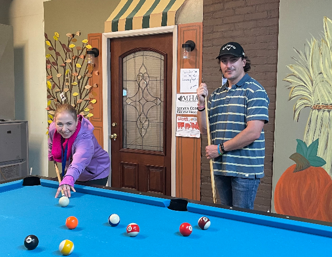 Twenty can sign-up, but only two will be prize-winners at the Mental Health Association’s First Ever Pool Tournament on three consecutive Friday nights, beginning November 5. Pictured practicing their shots are MHA Peer Carriee Clarke (left) and volunteer Rob Bruyer.