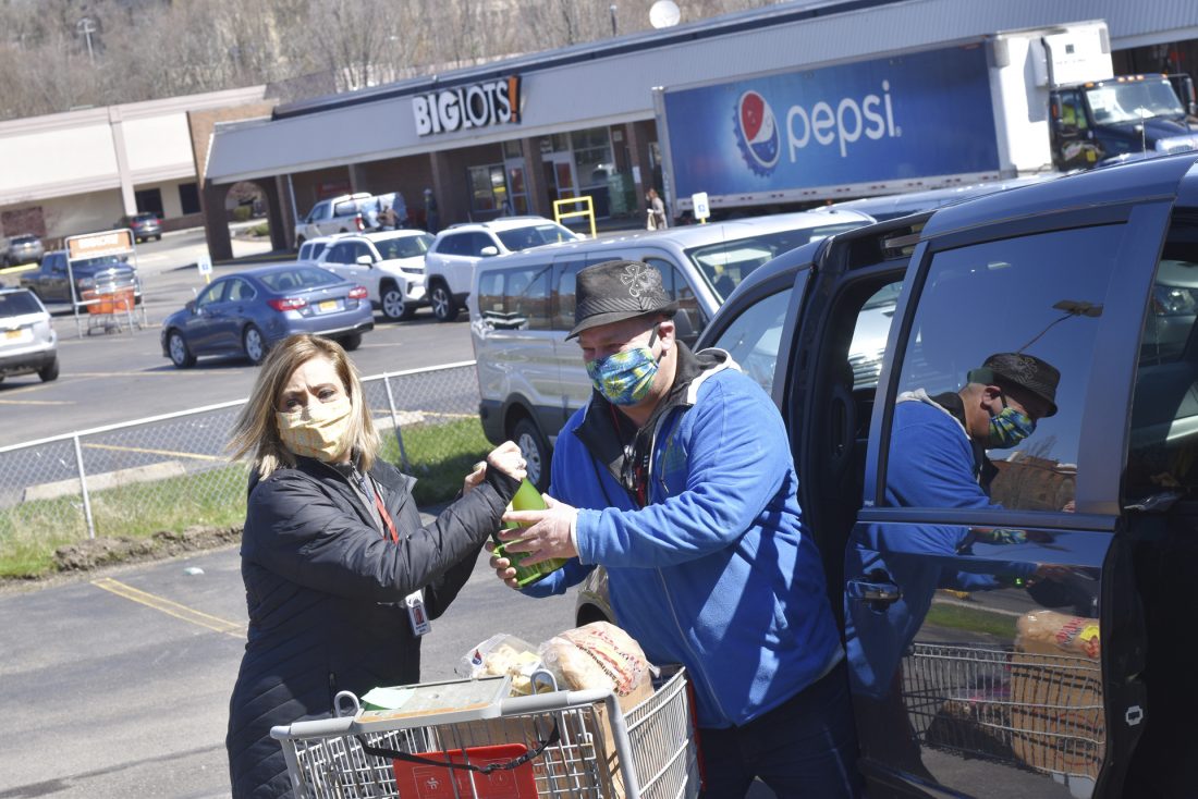 Dorothy Carlson and Ken Kendall of the Mental Health Association are pictured loading food into a van to be delivered Monday. P-J photo by Eric Tichy