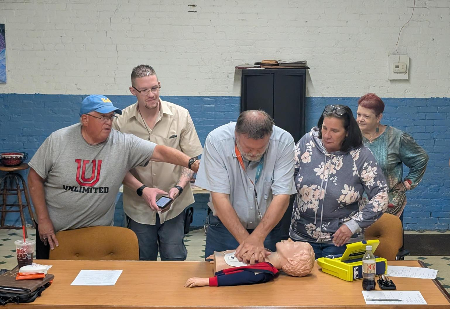 All Mental Health Association in Chautauqua County staff and volunteers recently received training in CPR and use of the AED purchased through a grant from Cummins Jamestown Engine Plant. Pictured from left are trainer Bob Goold, staffers Brandon Griggs, Michael Nordin, and Jill Marsh, and volunteer Tina Morgan.